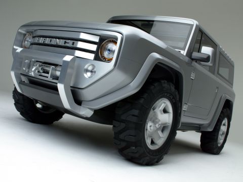 1990 Ford Bronco - Front three-quarter studio shot of a silver Ford Bronco concept SUV with chunky off-road tires and a 'BRONCO' grille.
