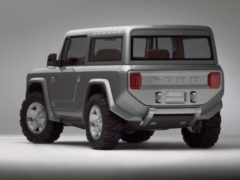 1990 Ford Bronco - Rear three-quarter studio shot of a silver Ford Bronco concept SUV showing a 'FORD' tailgate and off-road tires.
