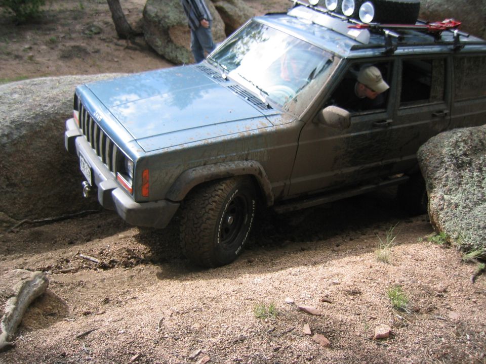 1997 Jeep Cherokee navigating rocky terrain, front-left tire turned