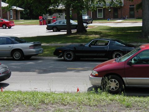 1997 Ford Taurus - A black 1978 Chevrolet Camaro Z28 is parked on the street, with other vehicles visible.