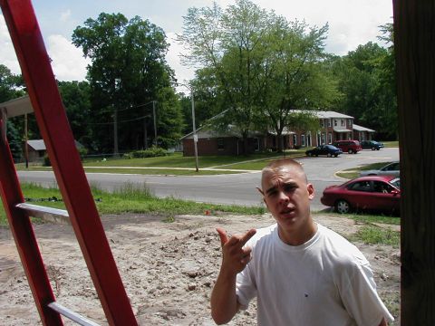 1997 Ford Taurus - Man in front of apartment buildings and parked cars, with a red ladder in the foreground.