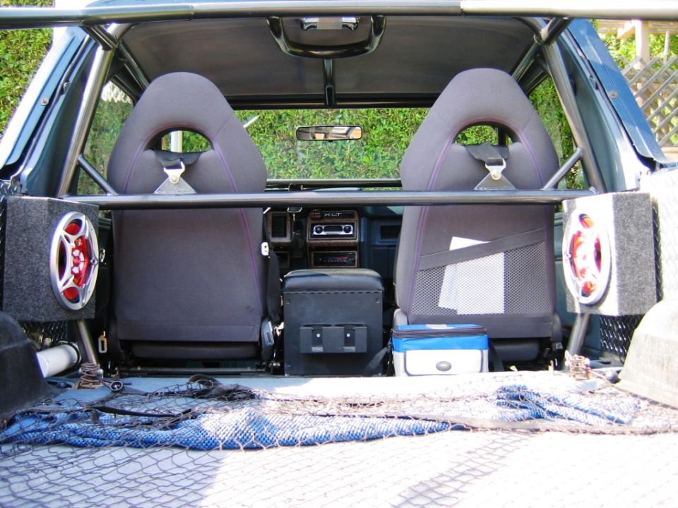 Bronco rear interior with bucket seats, center console, and carpeted speaker boxes