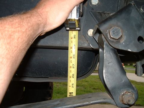 1995 Ford Bronco - A tape measure is used to gauge the height of a suspension component on a vehicle.