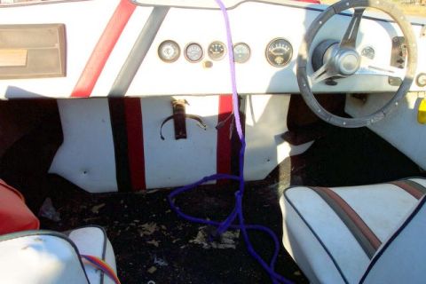 1990 Ford Bronco - Interior view of a boat's dashboard, showing gauges and a steering wheel.