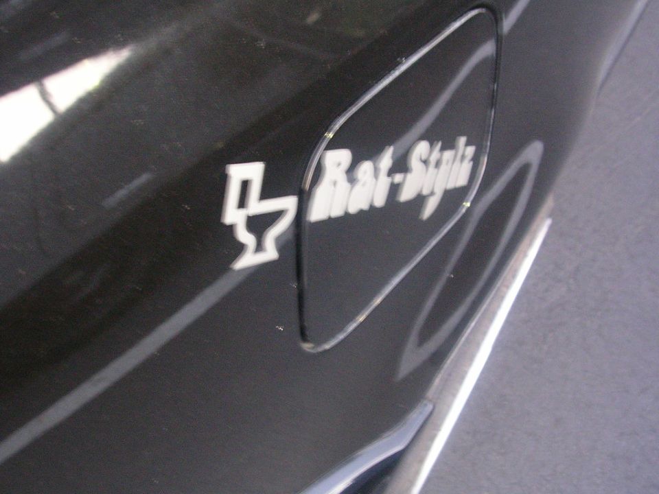 Black gas cap door with "Rat-Style" sticker and toilet icon