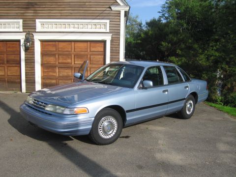 1991 Ford LTD Crown Victoria - Light blue 1991 Ford Crown Victoria LTD parked in front of a wooden garage door.