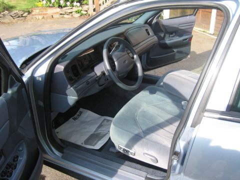 1991 Ford LTD Crown Victoria - The interior of a car is shown with the driver's side door open, revealing the dashboard and seats.