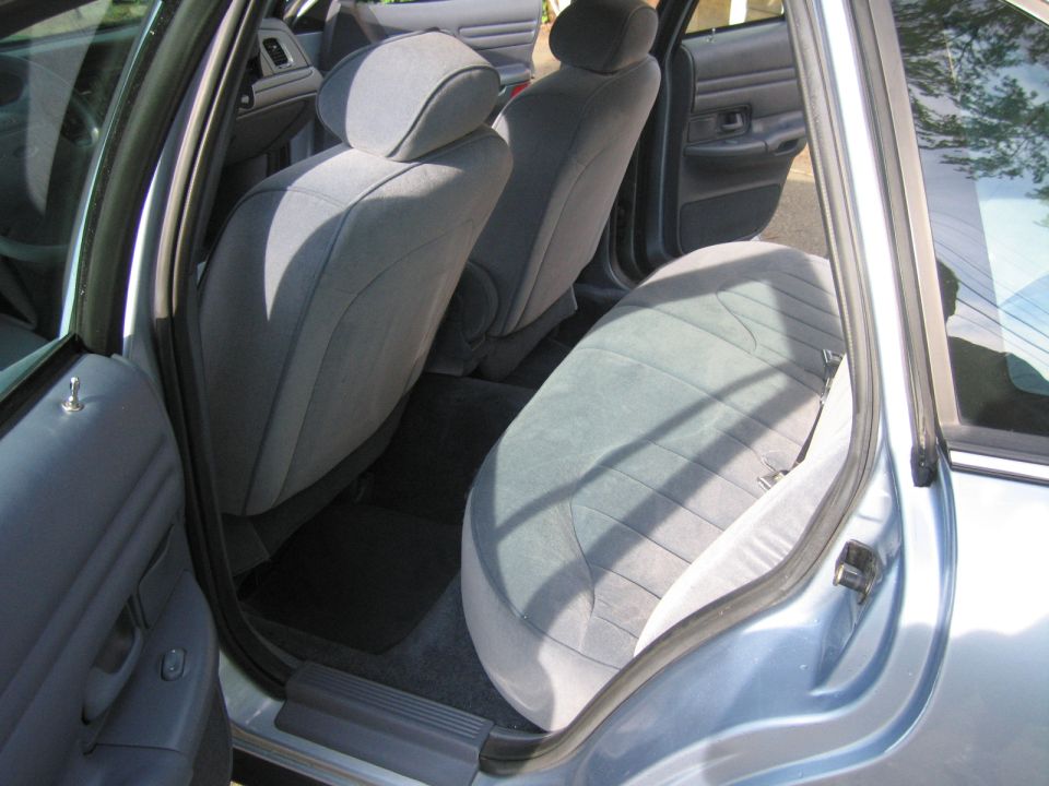 Light blue cloth interior of a 1991 Ford Crown Victoria LTD, showing front and rear seats, door panel, and floor mats