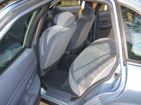 1991 Ford LTD Crown Victoria - The interior of a 1991 Ford Crown Victoria LTD features gray cloth seats and door panels, visible through the open doors.