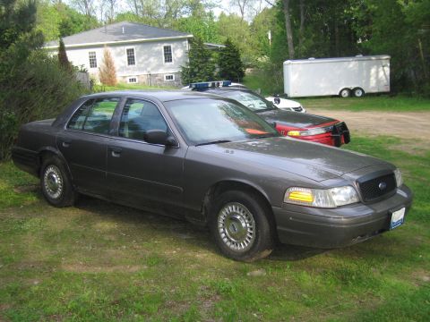 1991 Ford LTD Crown Victoria - A dark gray 1991 Ford Crown Victoria LTD sedan is parked on grass, with another vehicle visible behind it.