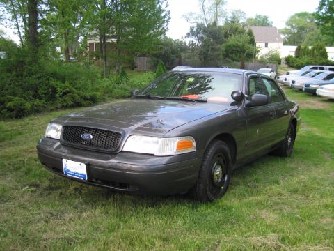 1991 Ford LTD Crown Victoria - Dark gray Ford Crown Victoria parked on grass with other vehicles in the background.