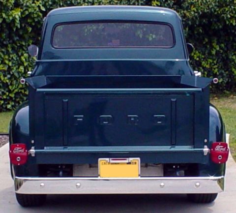 1956 Ford F-100 - The rear of a classic Ford pickup truck, its iconic tailgate lettering and rounded taillights.