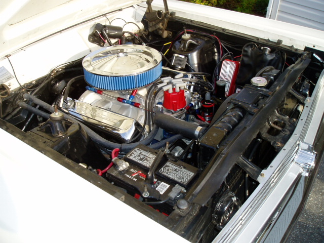 V8 engine bay with chrome air cleaner, finned valve covers and red distributor cap