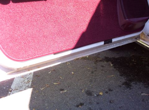 1991 Ford LTD Crown Victoria - Close-up view of the interior door sill and carpet of a vehicle.