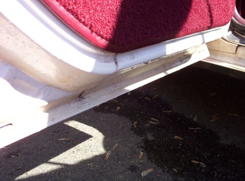 1991 Ford LTD Crown Victoria - Detail shot of a car's door sill and carpet, showing wear and tear.