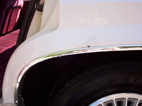 1991 Ford LTD Crown Victoria - A detail shot shows the wheel well and interior of a vehicle, with visible chrome trim and a portion of the tire.