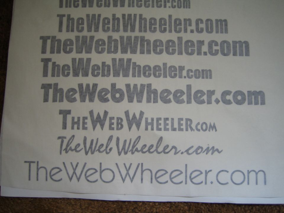Printed sheet showing 'TheWebWheeler.com' logo text in several fonts