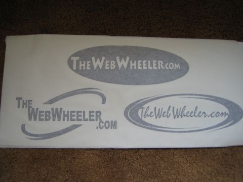 1990 Ford Bronco - printed page on carpet showing three TheWebWheeler.com logo concepts using ovals and a swoosh element.