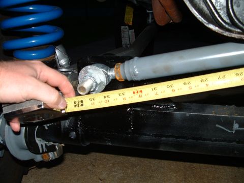 1995 Ford Bronco - A tape measure is used to measure a suspension component, likely for modification or repair.