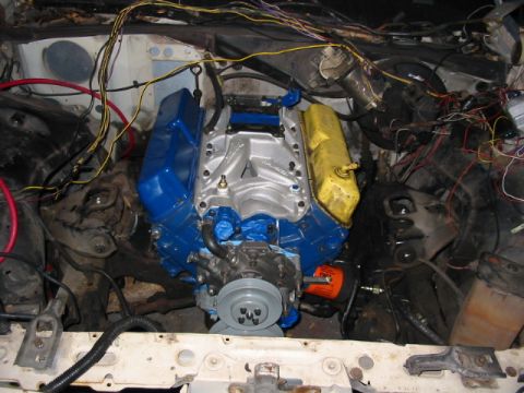 1985 Ford LTD Crown Victoria - The engine bay shows a V8 engine with blue and yellow valve covers and a silver intake manifold.