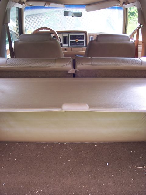 1986 Ford Bronco II - The interior of an older SUV, viewed from the rear cargo area, reveals tan upholstery and a dashboard.