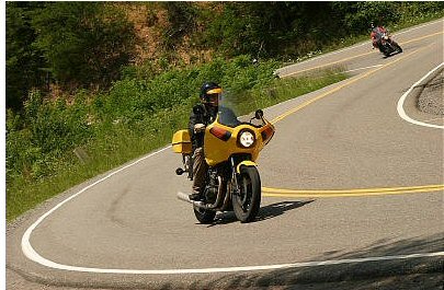 1985 Ford LTD Crown Victoria - Two motorcycles navigate a scenic, winding mountain road.