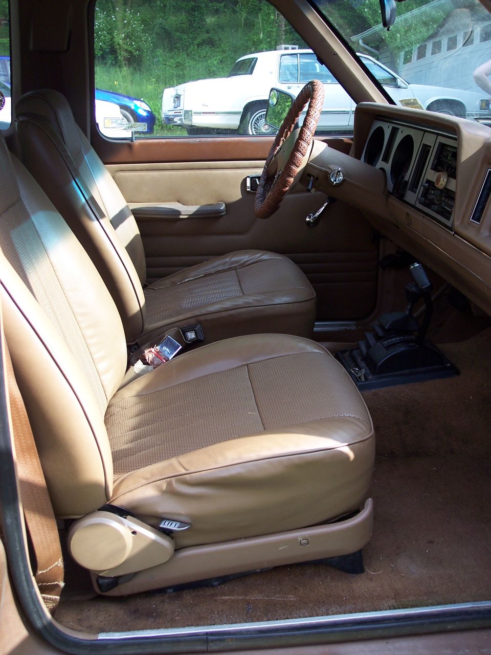 Tan front bucket seats and brown dash inside a compact Ford SUV, passenger-side view