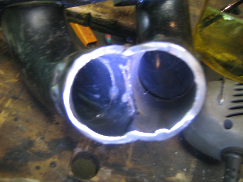 Close-up of a welded exhaust pipe with two openings
