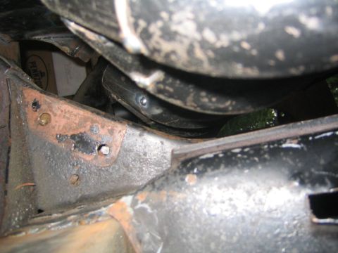 1978 Ford Bronco - Close-up of a rusty vehicle frame and exhaust system, with a box labeled 'PENTON' in the background.