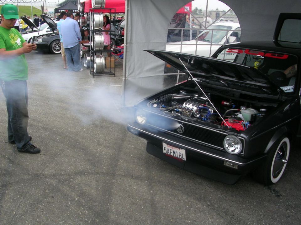 Black Volkswagen Golf Mk1 with smoke billowing from the open hood
