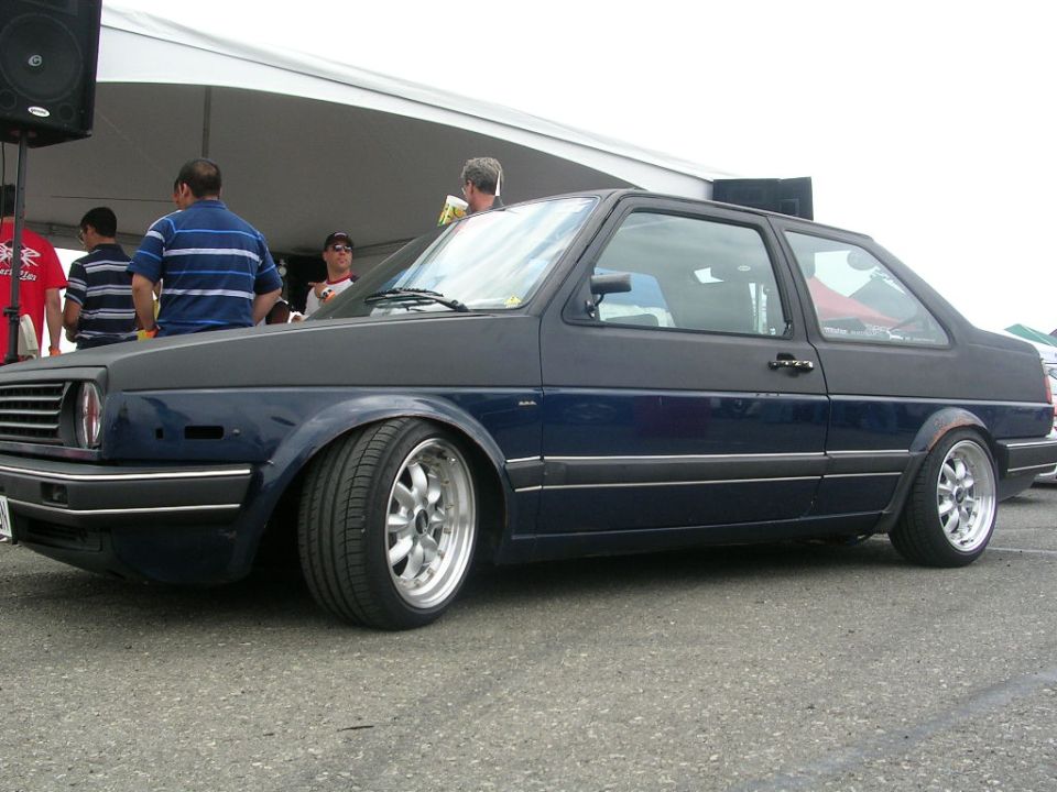 Dark blue hatchback with aftermarket wheels, lowered stance