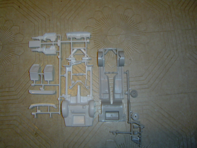 Model car chassis and engine parts on a textured surface