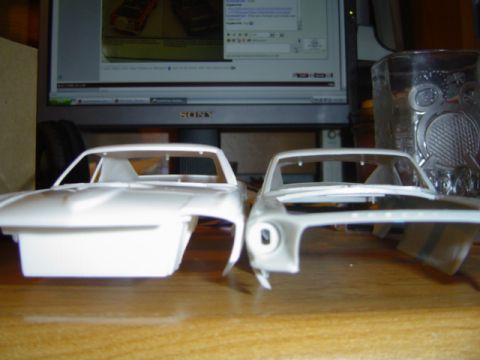 1979 Ford Bronco - Two unpainted model car bodies are displayed side-by-side on a table.