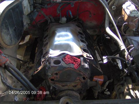 1978 Ford Bronco - The engine bay of a vehicle is shown with the intake manifold removed, revealing the engine block and cylinder heads.