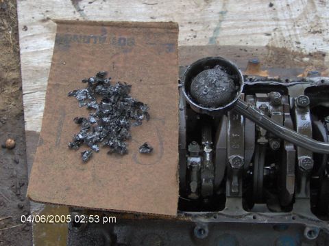 1978 Ford Bronco - Debris collected on cardboard next to an engine block and oil filter. The image includes a date stamp and a Supermotors.net watermark.