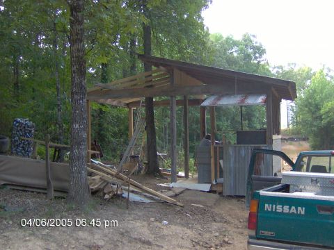 1978 Ford Bronco - A Nissan pickup truck is visible at a construction site with a partially built structure and trees in the background.