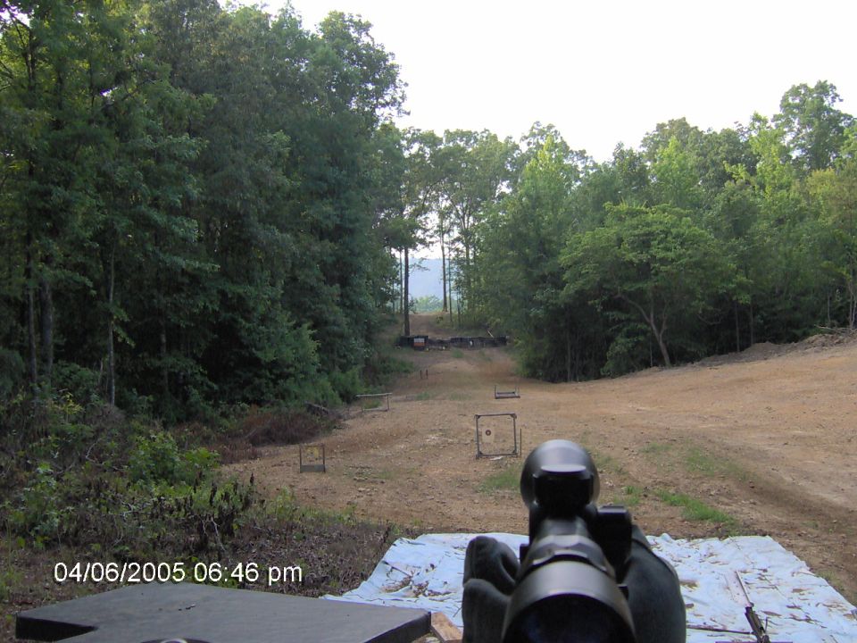 shooting range with targets set up in the distance, view from behind a rifle scope