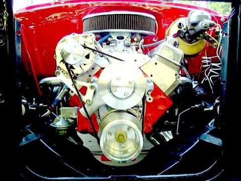 1994 Ford Bronco - Engine bay view of a V8 engine with custom chrome components and red block.