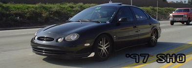 1993 Ford Taurus - A black sedan is seen on the highway, with text overlay indicating '97 SHO.