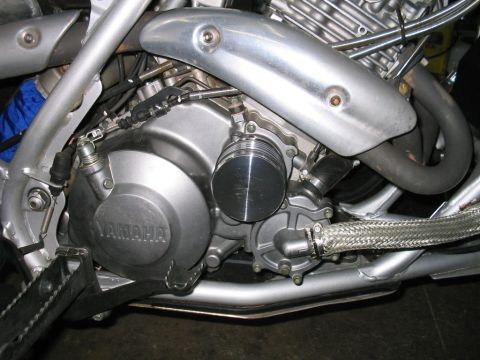 1991 Ford Bronco - The engine of a Yamaha motorcycle is visible, with its crankcase and exhaust system in focus.