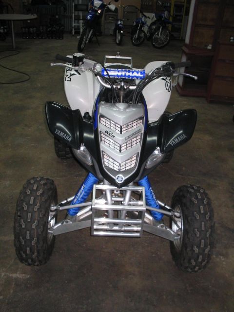 1991 Ford Bronco - A Yamaha Raptor ATV is parked indoors, with other motorcycles visible in the background.