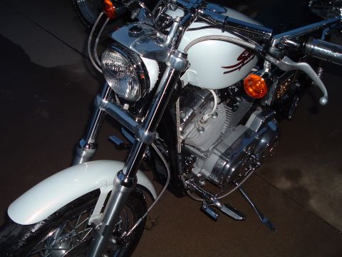 2000 Harley-Davidson Sportster - A white Harley-Davidson motorcycle is parked, showing its front wheel, fender, and engine details.
