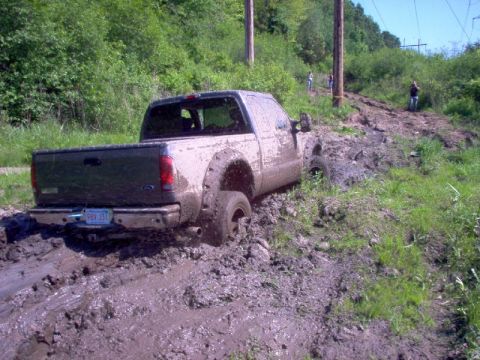 1976 GMC C/K Pickup - This truck is really stuck in the mud, with people observing from the hillside.