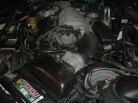 1993 Ford Taurus - A close-up view of a car's engine bay, showing the battery and intake system.