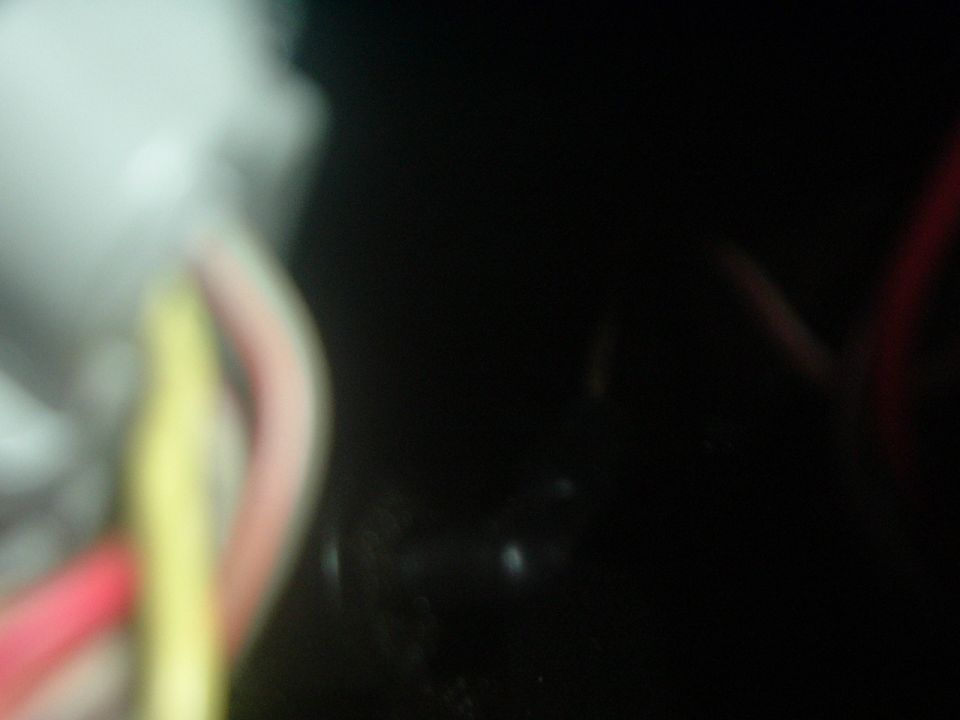 Close-up of red, yellow, and pink wires against a black background
