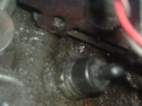 1993 Ford Taurus - Engine part detail with a red wire, focus is unclear.