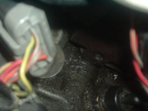 1993 Ford Taurus - Close-up of an engine bay shows a wiring harness connected to a grimy engine block.