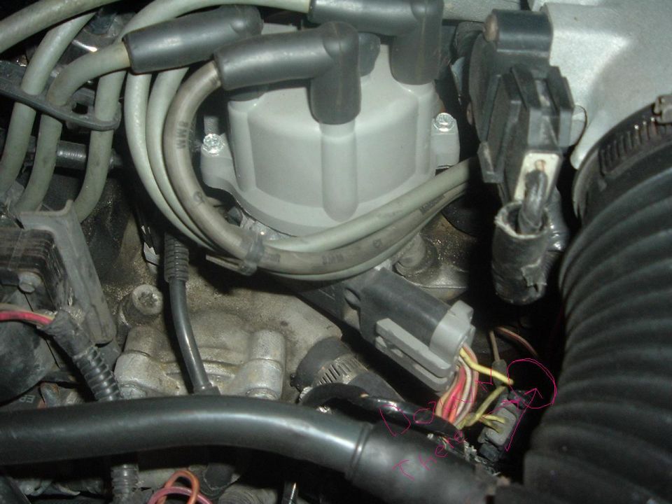 Close-up of a car's distributor cap, spark plug wires, and electrical connectors