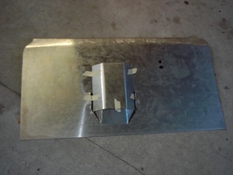 1978 Ford Bronco - A metal panel with a fabricated bracket is taped in place over a cut-out section.