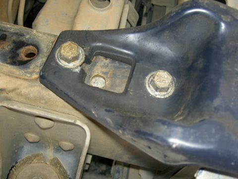 1988 Ford Bronco - Close-up of a vehicle's frame bracket and mounting bolts.